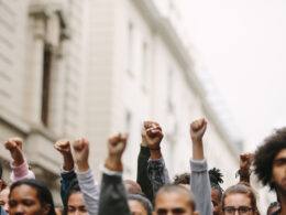 A crowd of protesters raising their fists during a demonstration, showing unity and activism