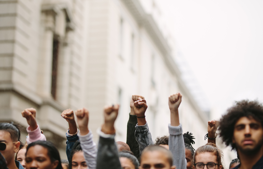 A crowd of protesters raising their fists during a demonstration, showing unity and activism